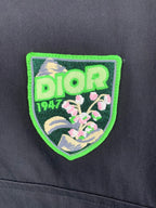 Green-and-black Dior logo patch on a dark gray jacket front