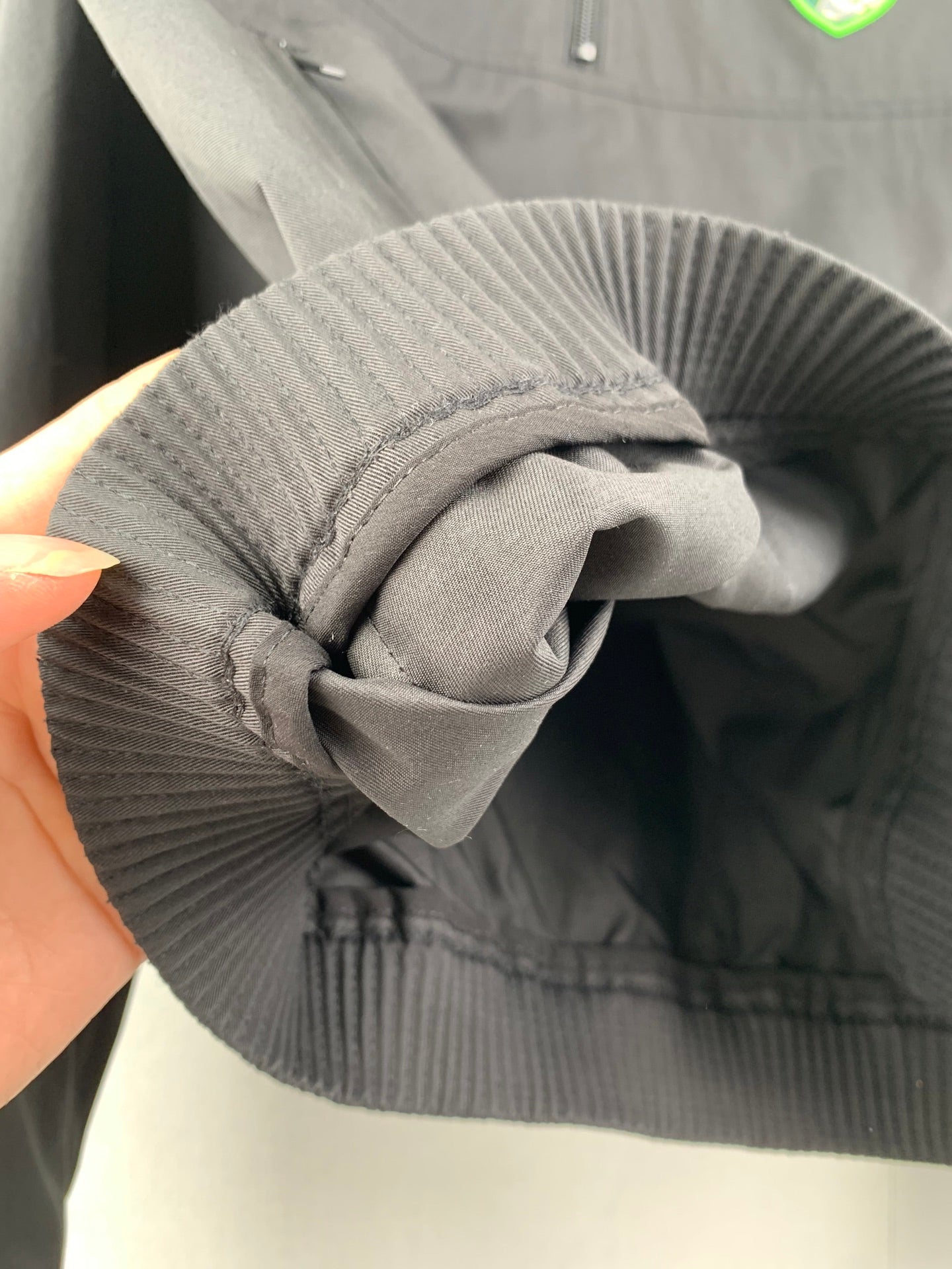 Ribbed hood opening and drawcord detail on a dark gray Dior jacket