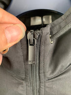 Close-up of Dior zip pull and zipper on a dark gray jacket