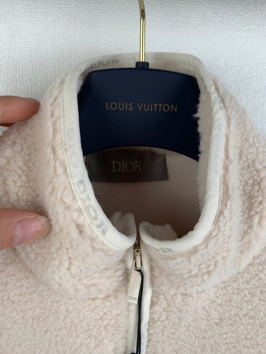 Cream sherpa jacket neckline and zipper area close-up with hanging brand labels