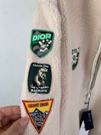 Ivory sherpa jacket sleeve patches with crest and mountain designs