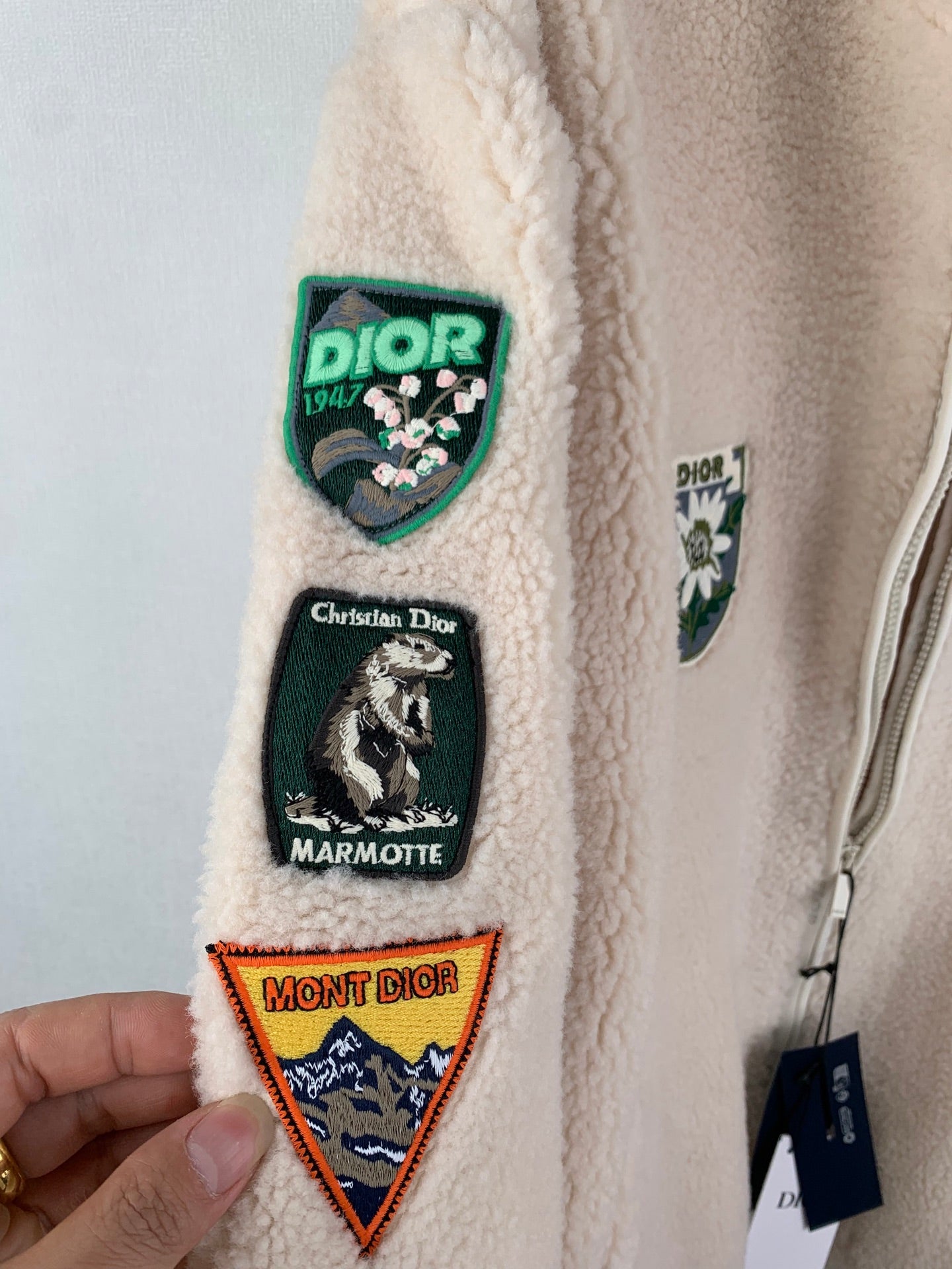 Ivory sherpa jacket sleeve patches with crest and mountain designs