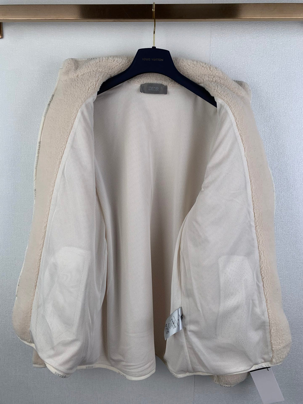 Ivory sherpa zip-up jacket interior lining with cuffs and collar visible