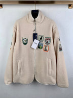 Ivory sherpa zip-up jacket with front pockets and colorful embroidered patches