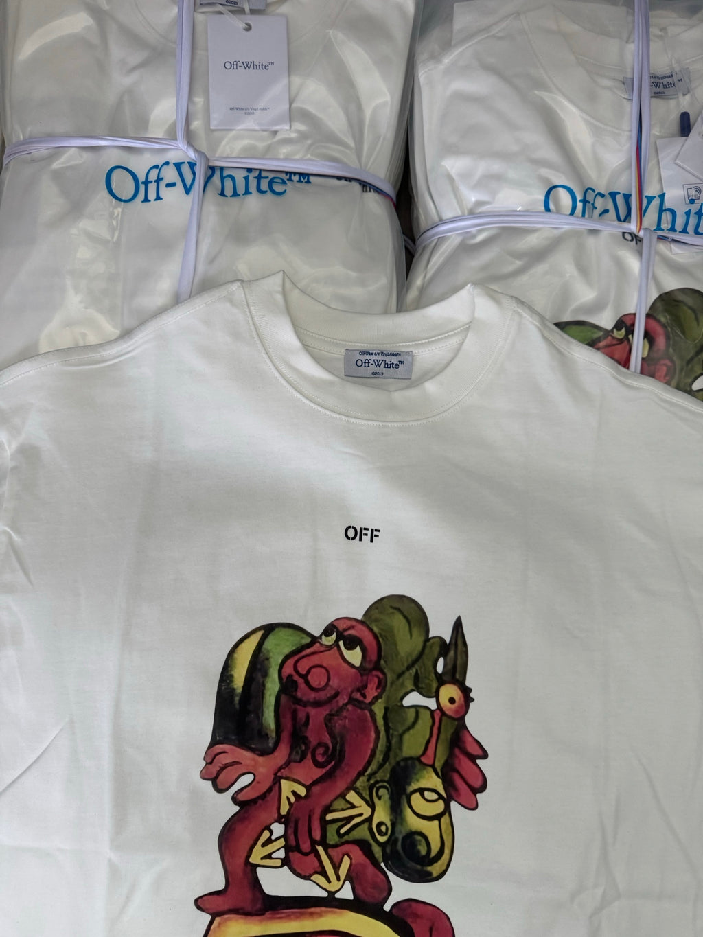 Off-white T-shirt with OFF text and colorful character graphic, crew neck