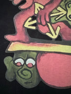 Black T-shirt with colorful cartoon character and shoe graphic, close-up