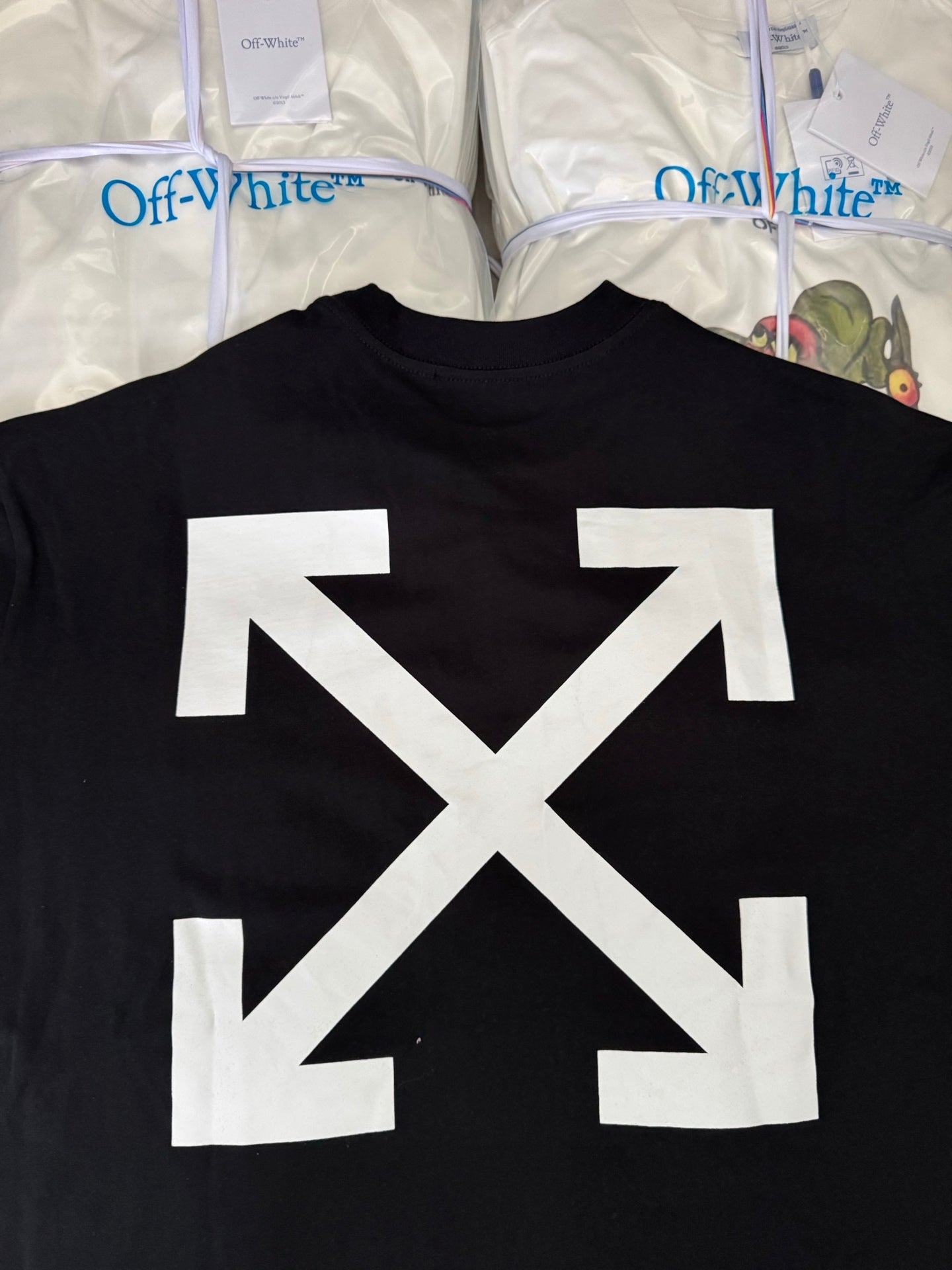 Black T-shirt back with oversized white arrow X graphic, close-up
