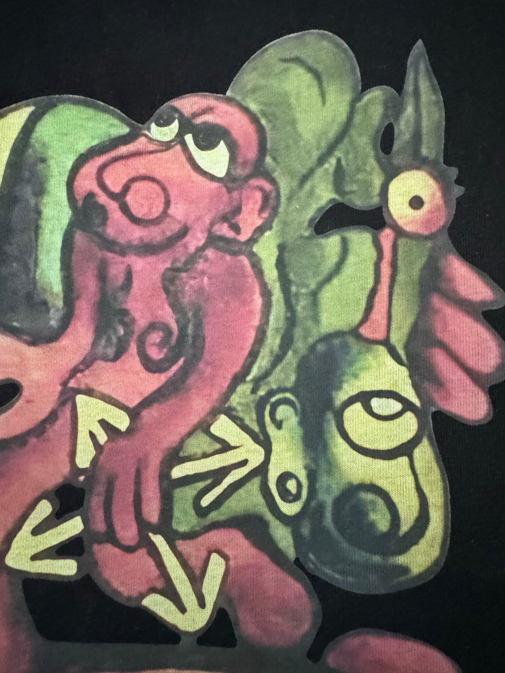 Black T-shirt with large colorful cartoon characters graphic, close-up
