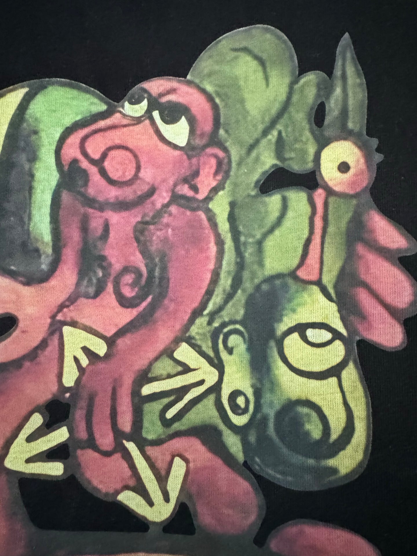 Black T-shirt with large colorful cartoon characters graphic, close-up