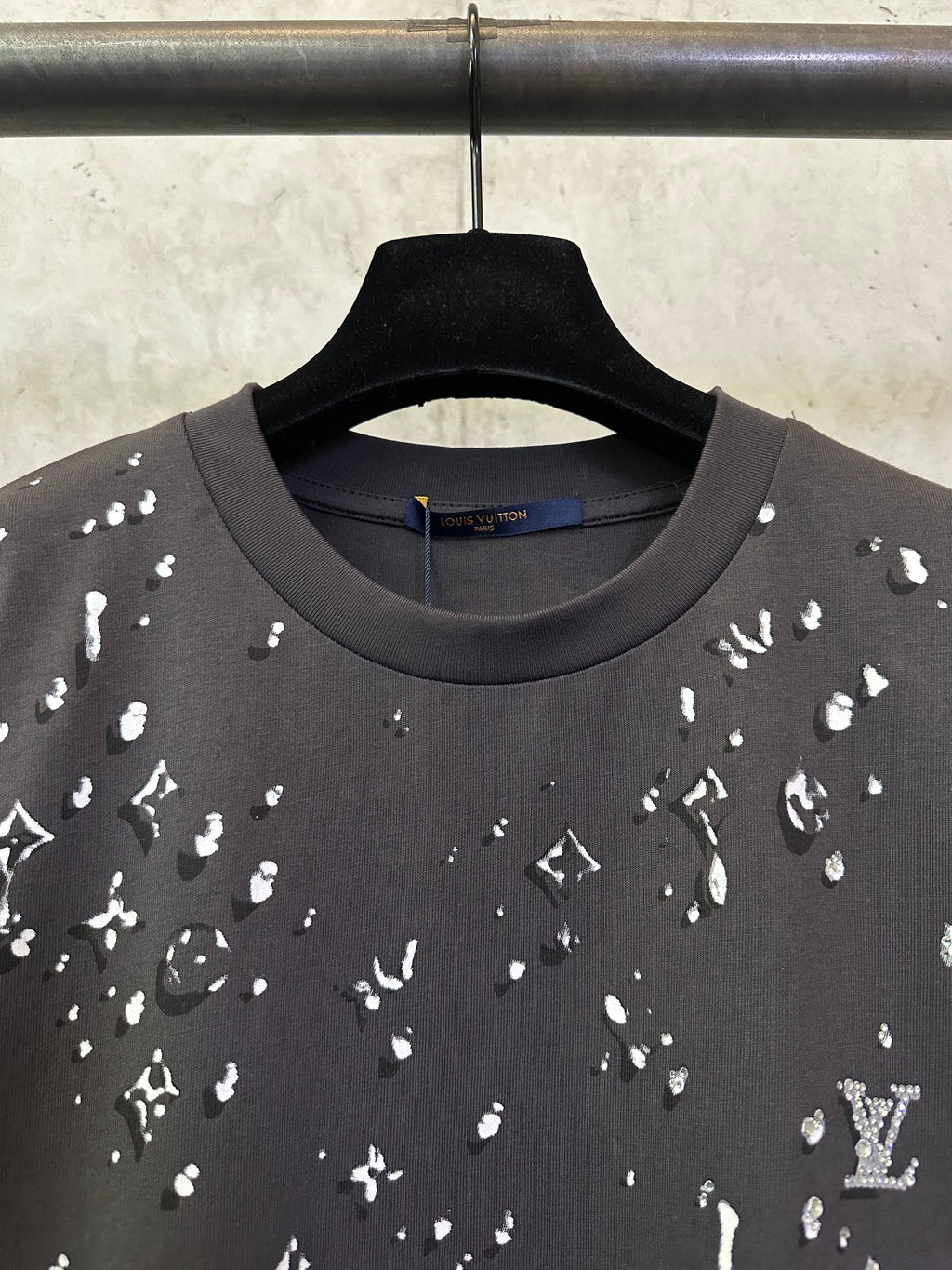 Black crewneck T-shirt with scattered white motif print, neckline close-up