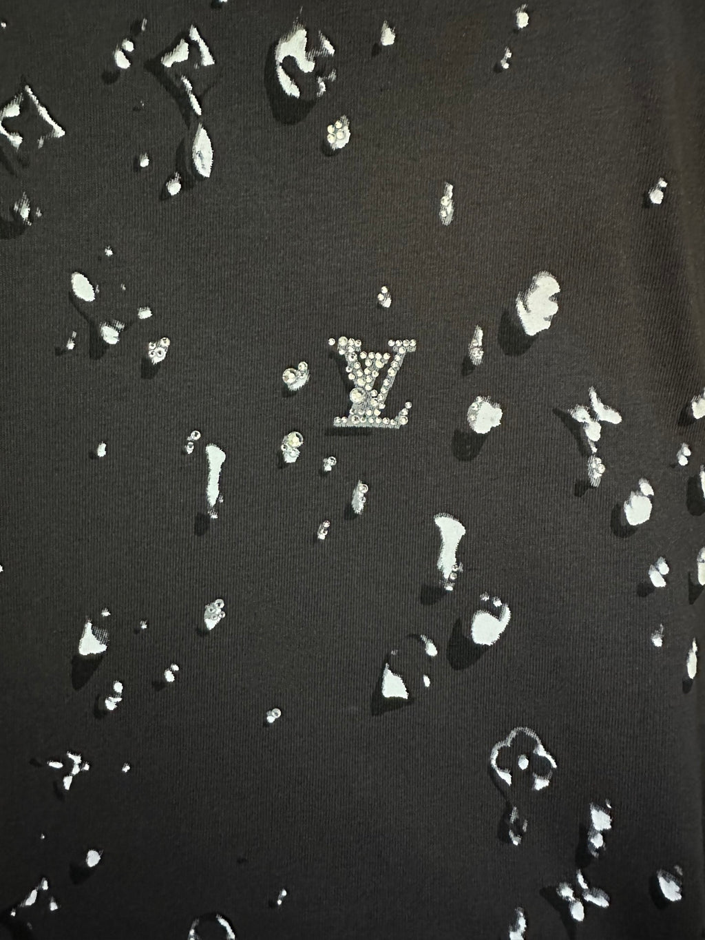 Black fabric with scattered white LV-style motif print pattern