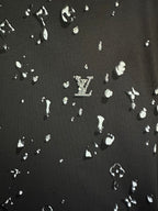 Black fabric with scattered white LV-style motif print pattern