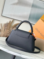 Navy leather tote-style handbag with top handle, front pocket, and shoulder strap