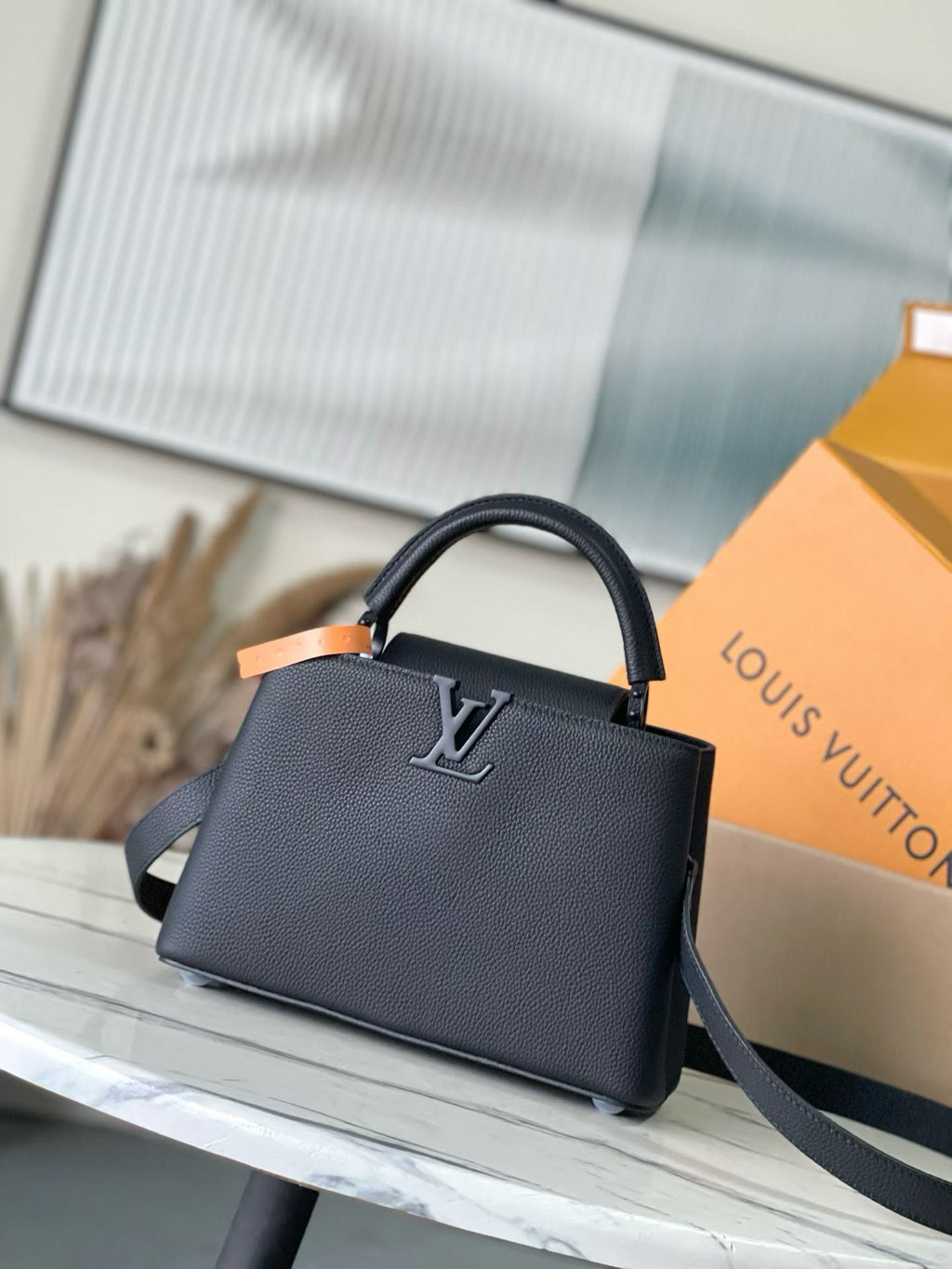 Dark textured handbag with top handle, LV logo, and shoulder strap