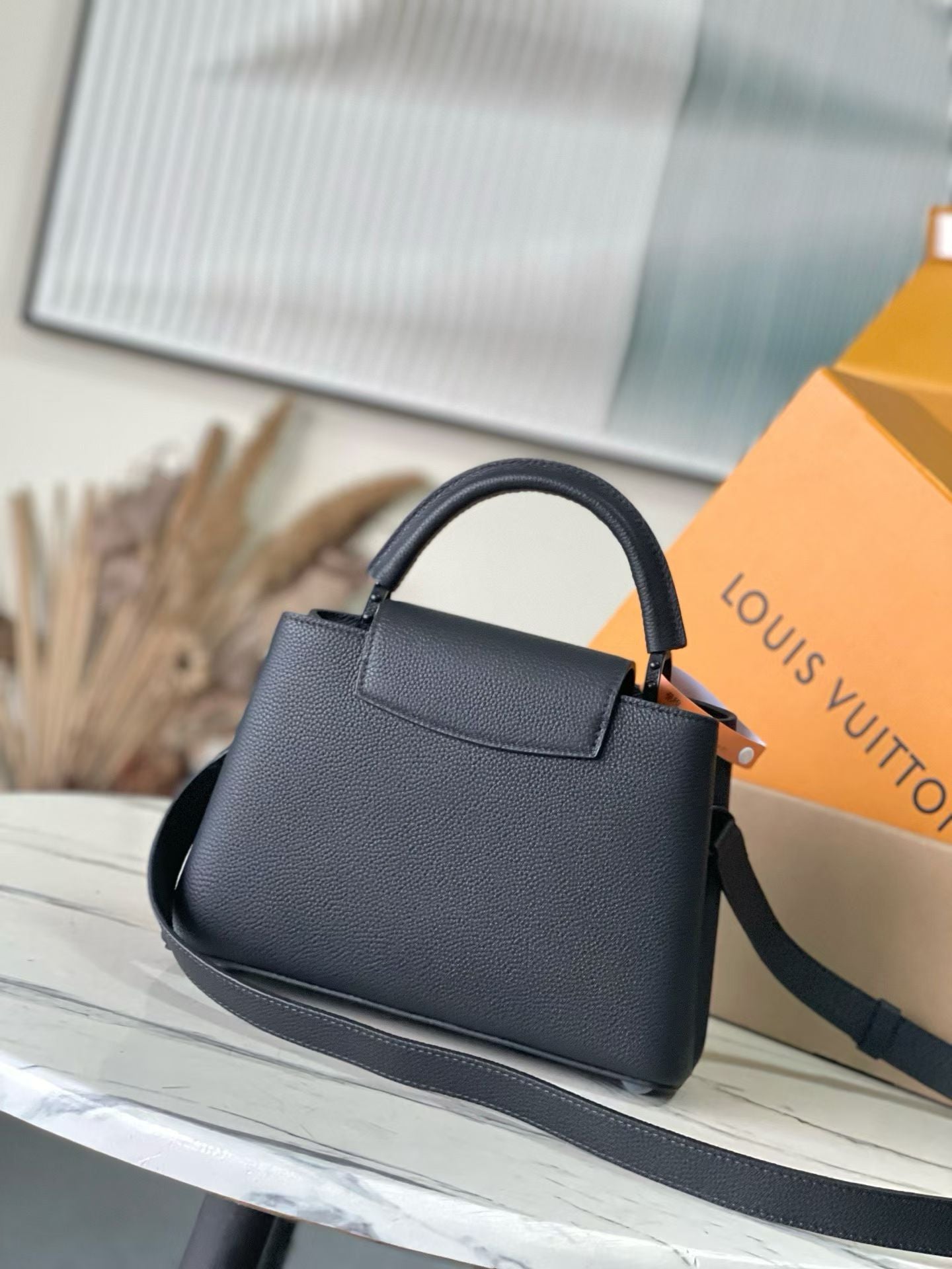 Dark structured handbag with short top handle and shoulder strap