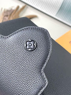 Dark leather handbag with embossed four-petal emblem on front