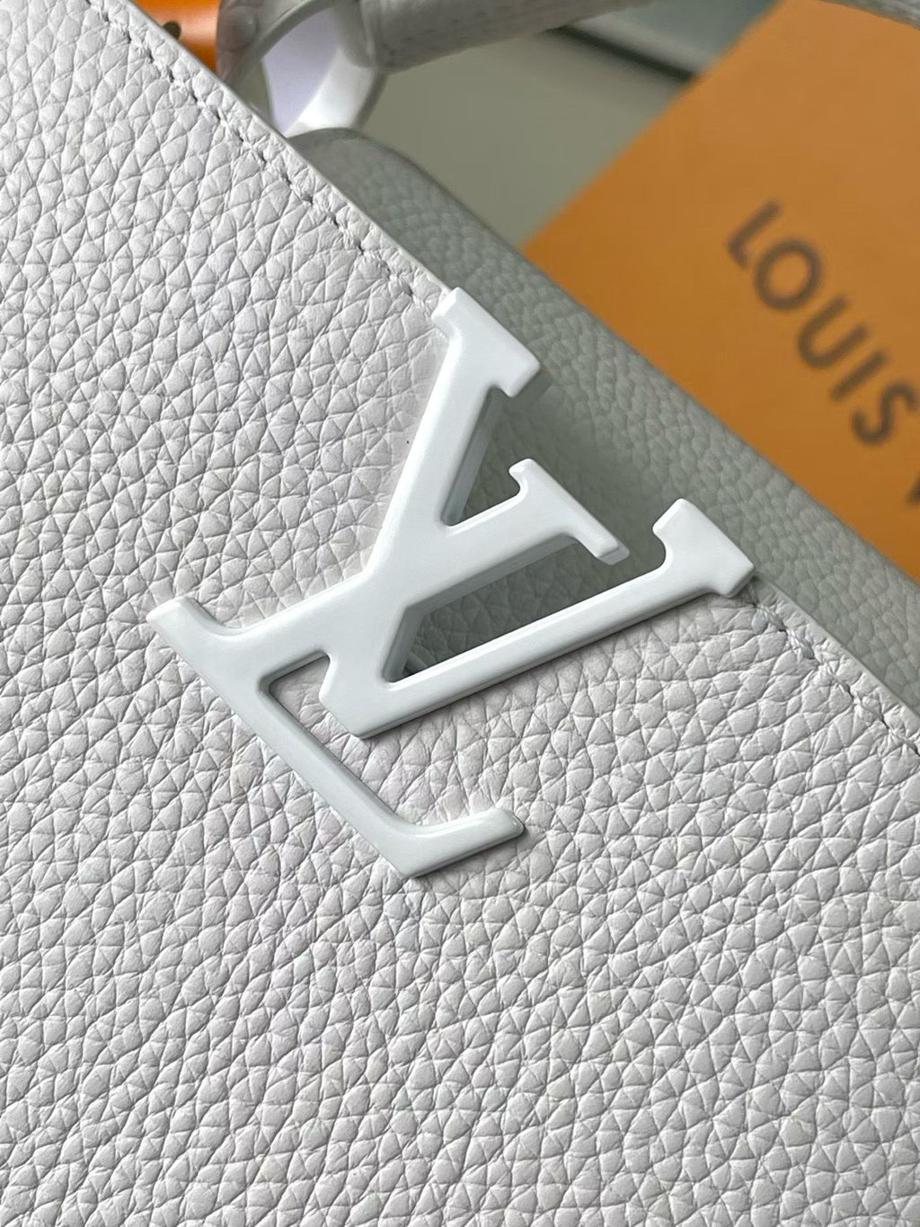 Louis Vuitton embossed LV monogram on white leather strap
