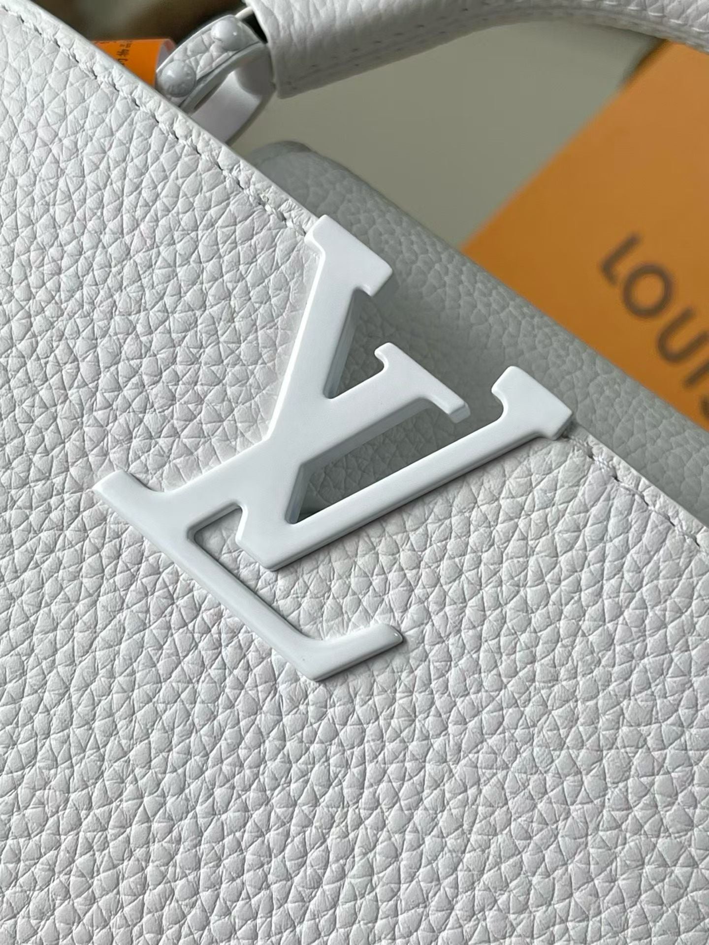 White textured leather handbag with engraved LV monogram emblem