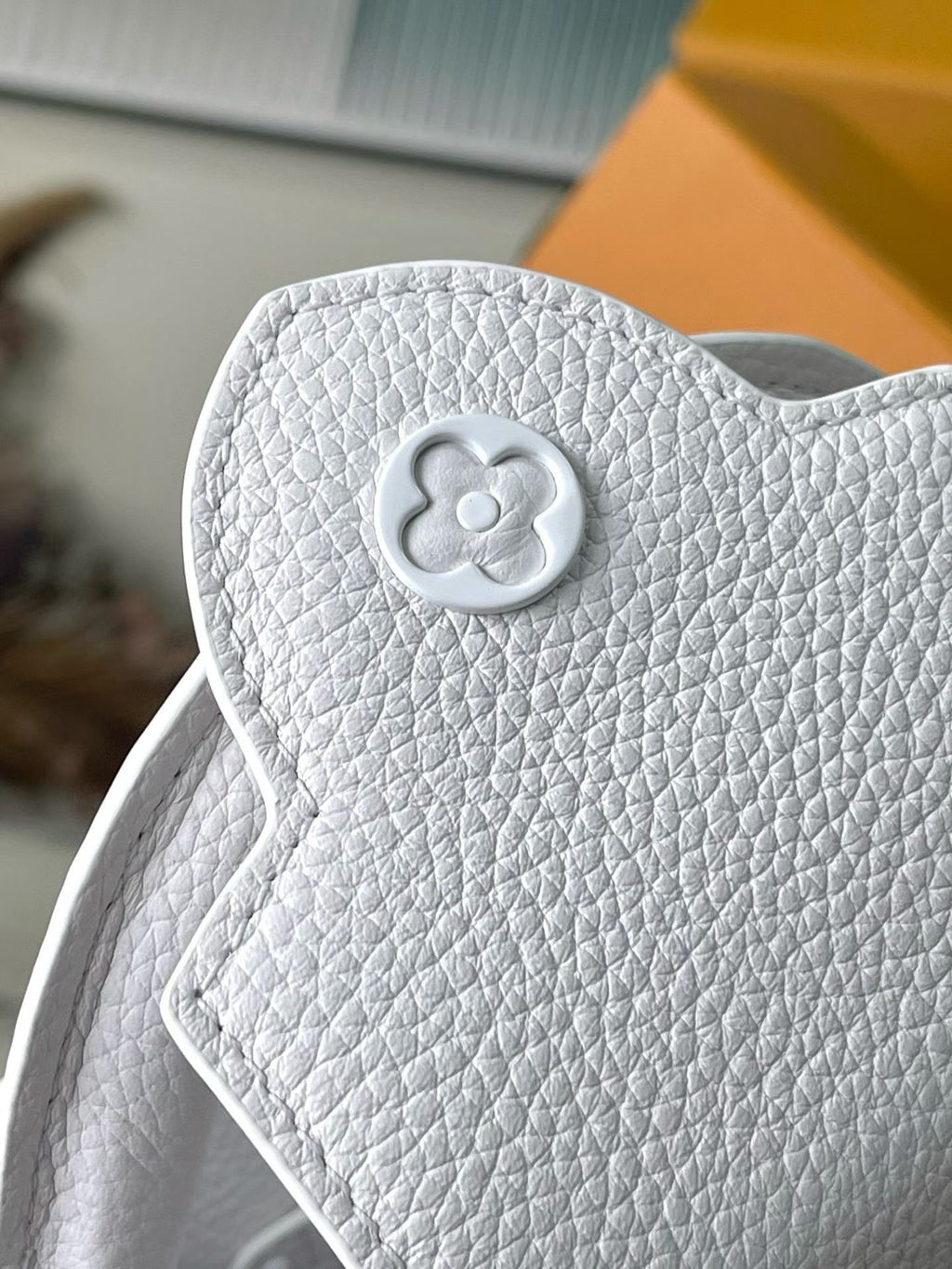 White pebble-grain handbag with clover-shaped snap button on the front