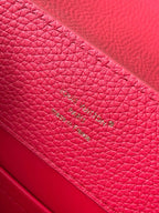 Red leather handbag with stamped Louis Vuitton text on interior panel