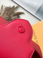 Red leather handbag flap with embossed monogram button, Louis Vuitton