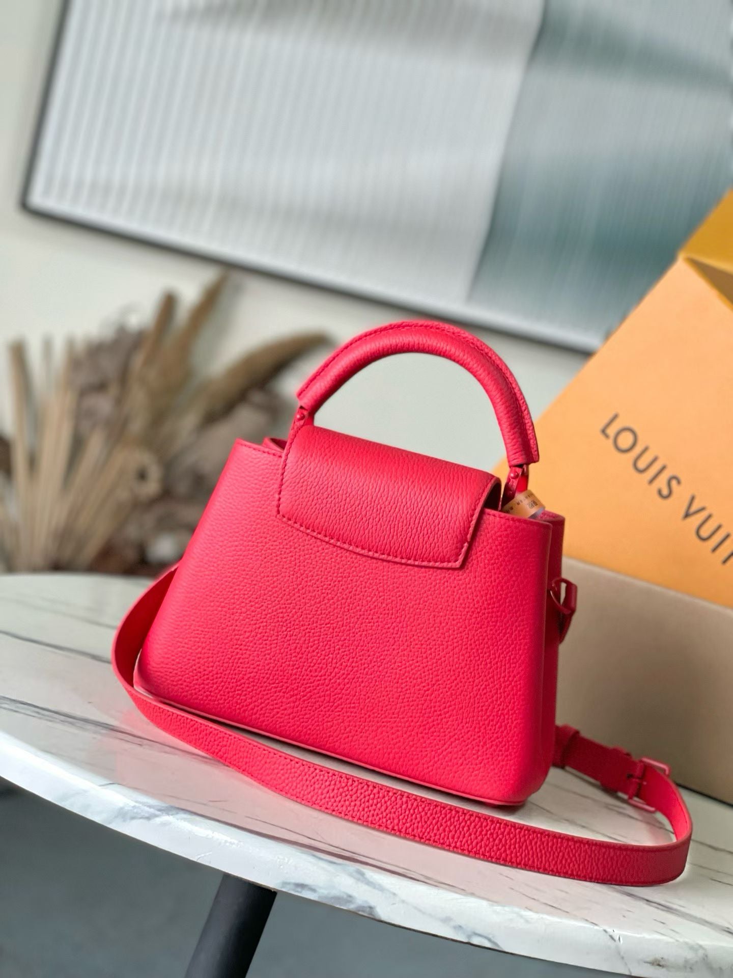 Red leather handbag with structured top handle and shoulder strap, Louis Vuitton