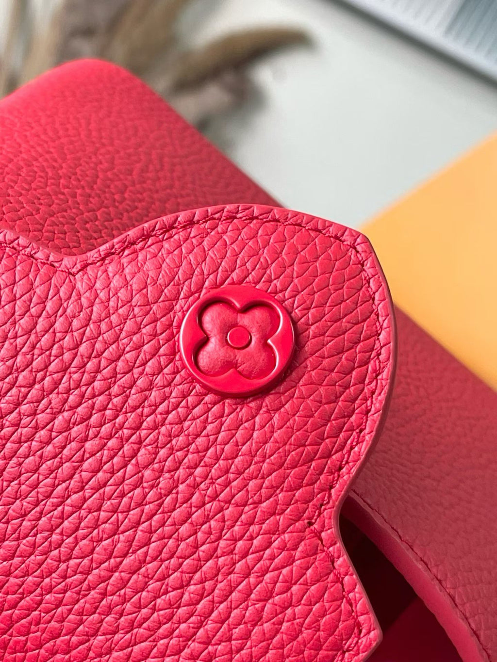 Red leather mini handbag with embossed medallion on side flap