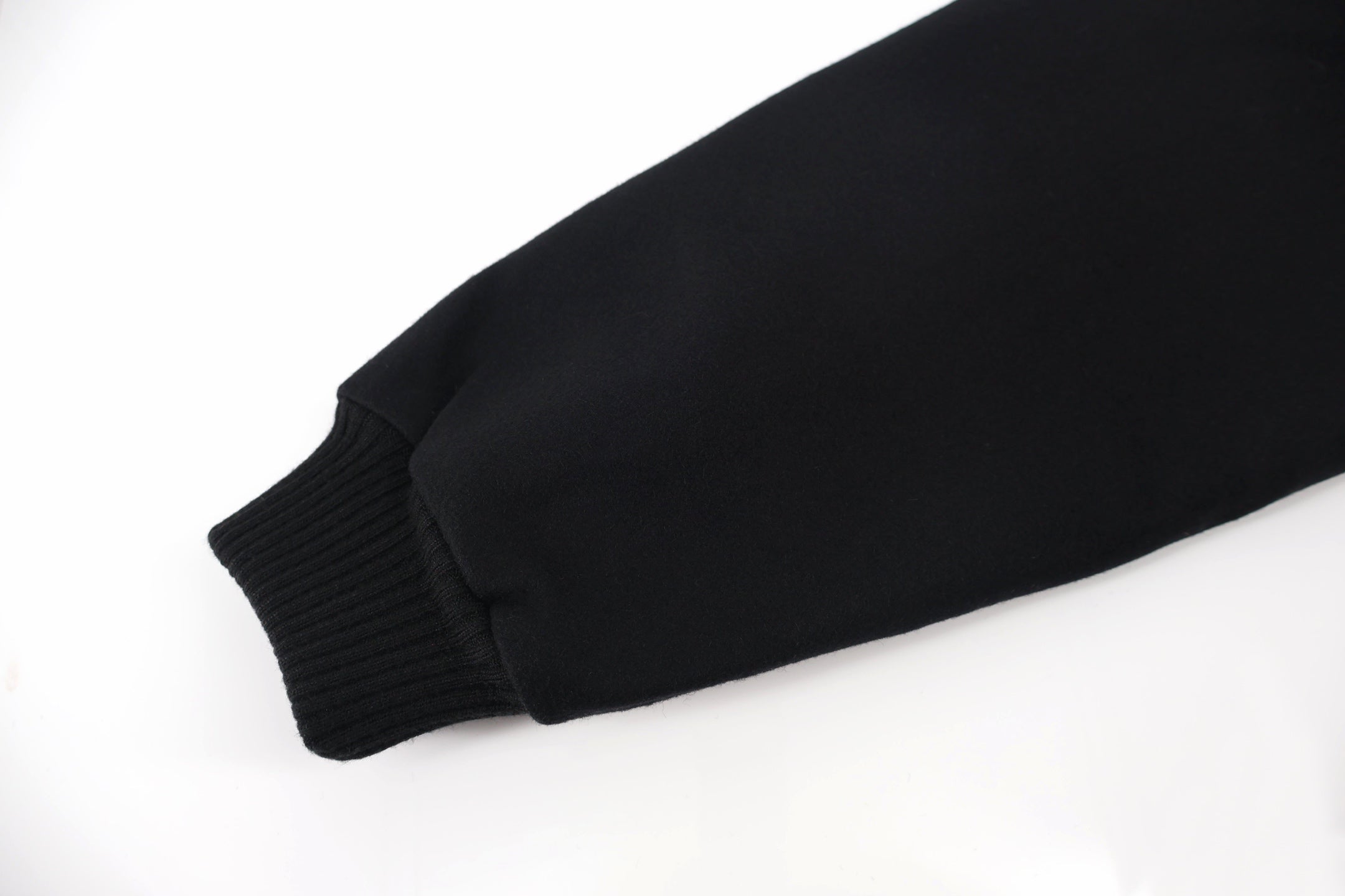 Black jacket sleeve end with ribbed knit cuff