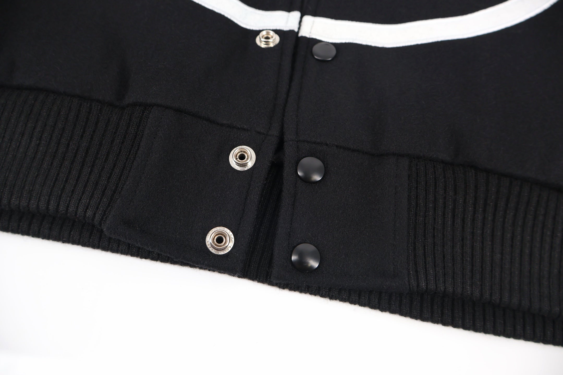 Black jacket waistband with ribbed hem and snap button placket