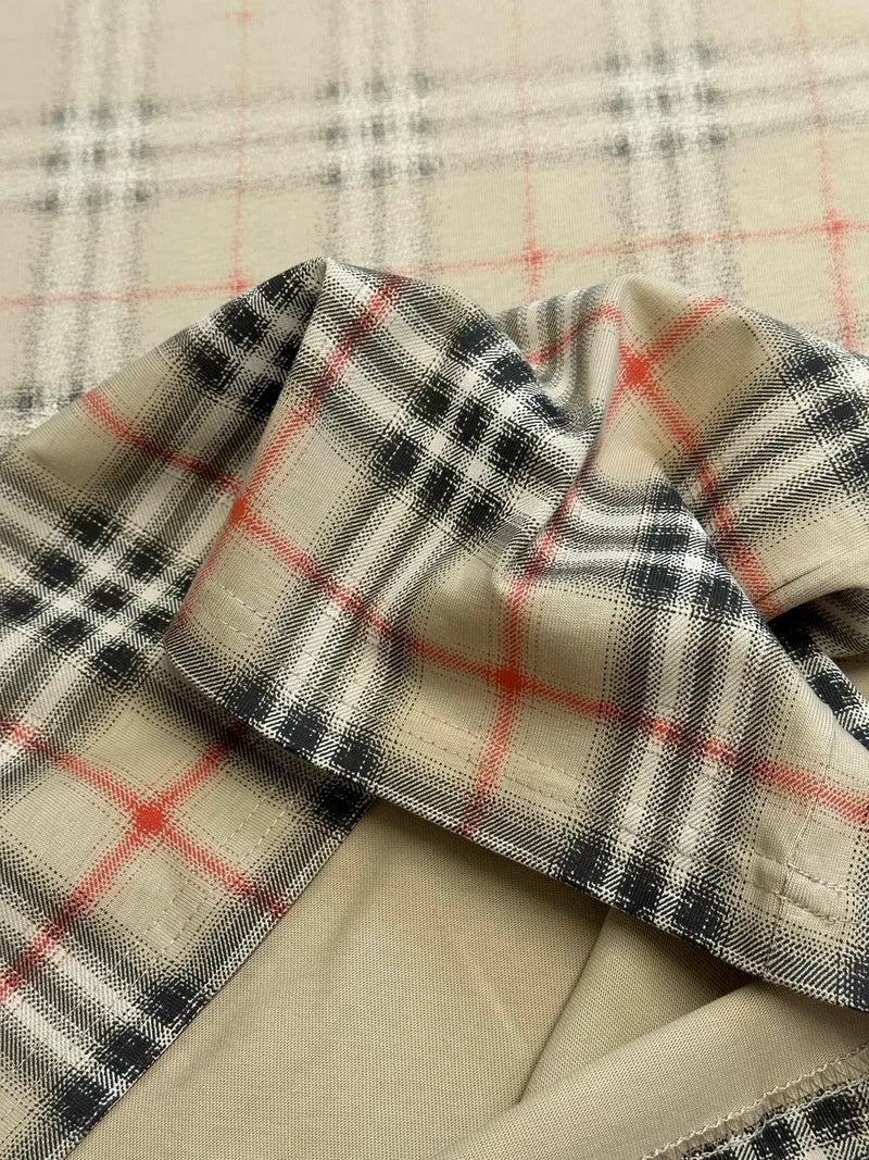 Plaid fabric sleeve cuff on a beige short-sleeve top