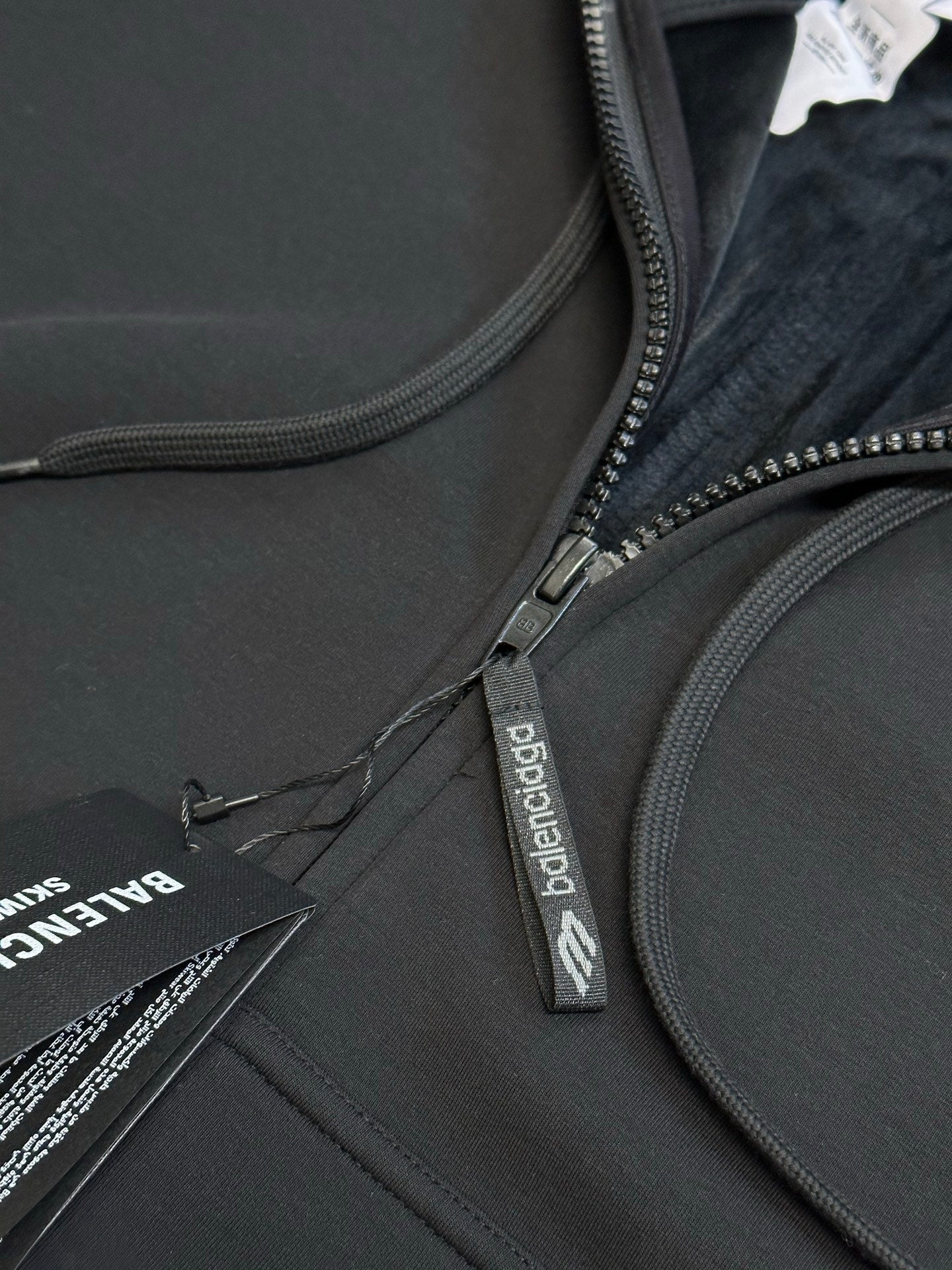 Black Balenciaga zip-up hoodie close-up of front zipper and drawstring cord