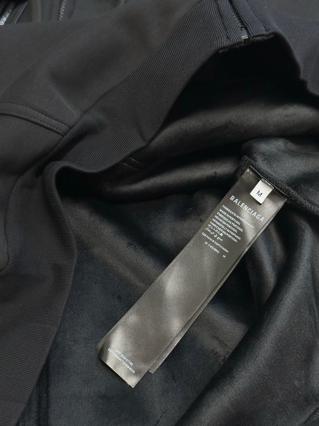 Black Balenciaga zip-up hoodie fabric with hanging brand label tag