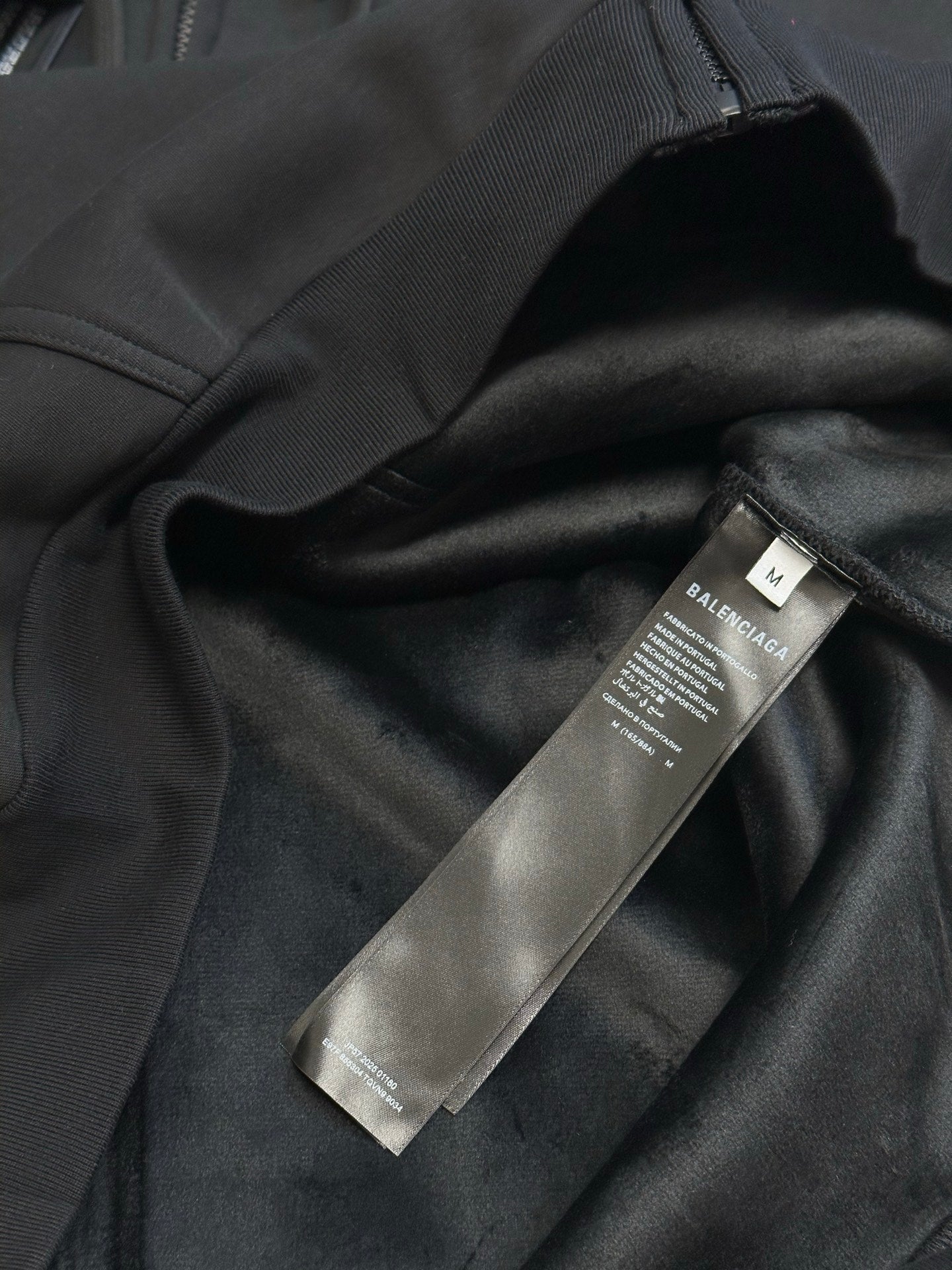 Black Balenciaga zip-up hoodie fabric with hanging brand label tag