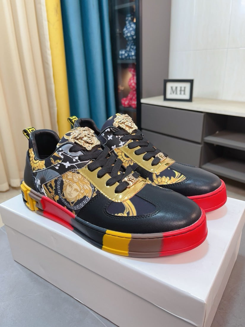 Luxury Versace lace-up sneakers on white box, black with gold pattern and red-yellow sole