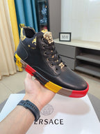 Black lace-up high-top sneaker with gold emblem lace tab and red/yellow outsole trim