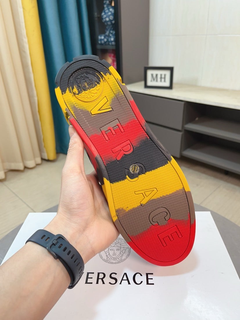 Shoe outsole view of black high-top sneaker with yellow-red tread pattern