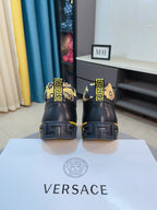 Back view of black high-top sneakers with gold patterned heel accents and embossed outsole