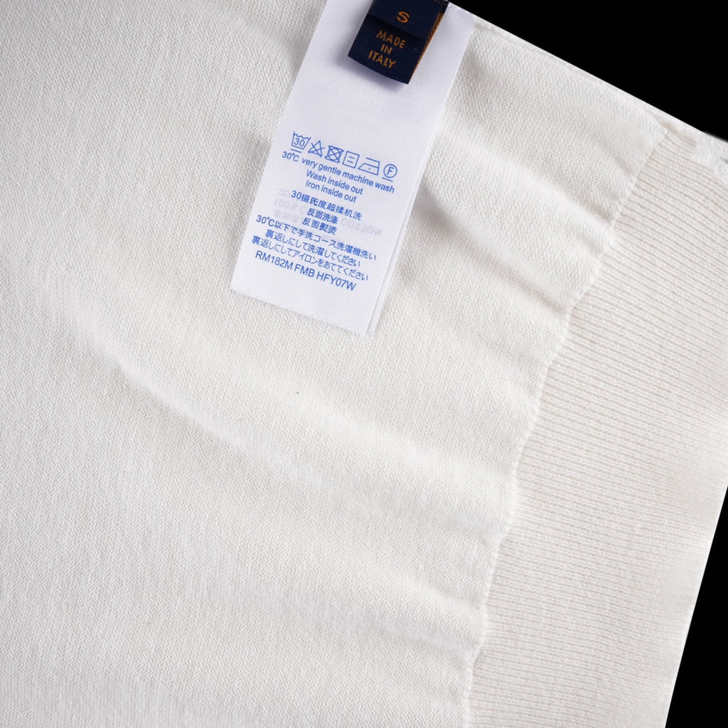 White T-shirt care label with size and fabric info on inner neck