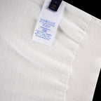White T-shirt care label with size and fabric info on inner neck