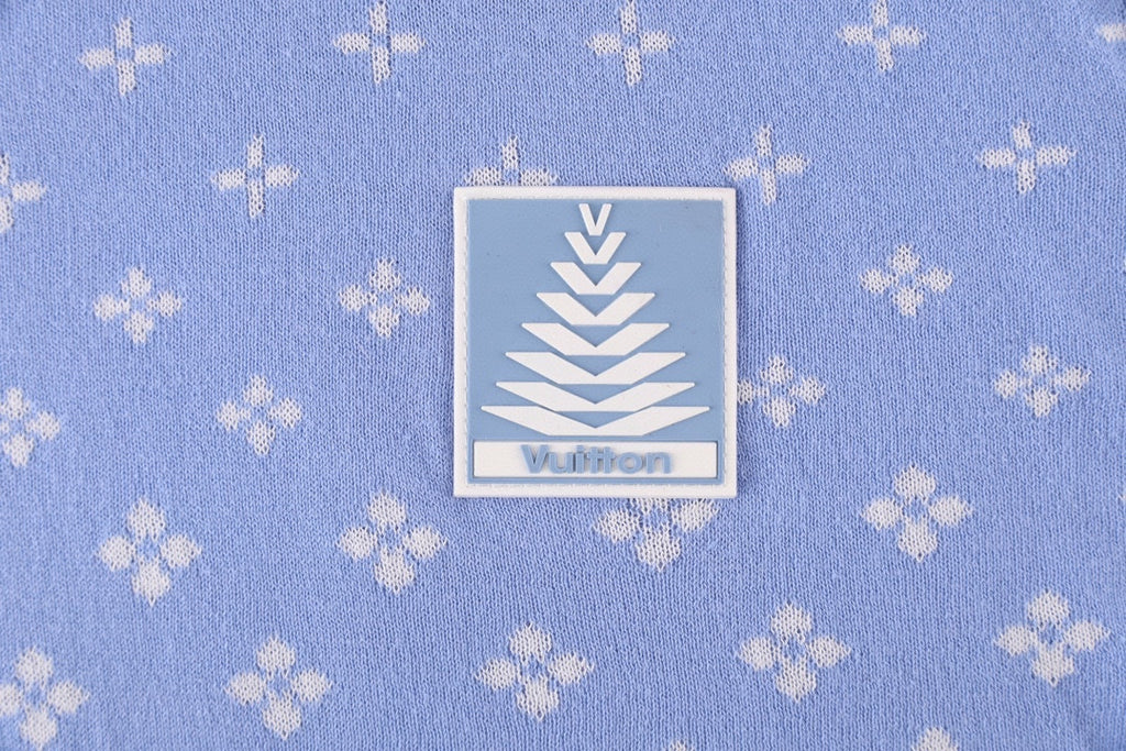 Close-up of a light blue fabric label with logo on a repeating white pattern shirt