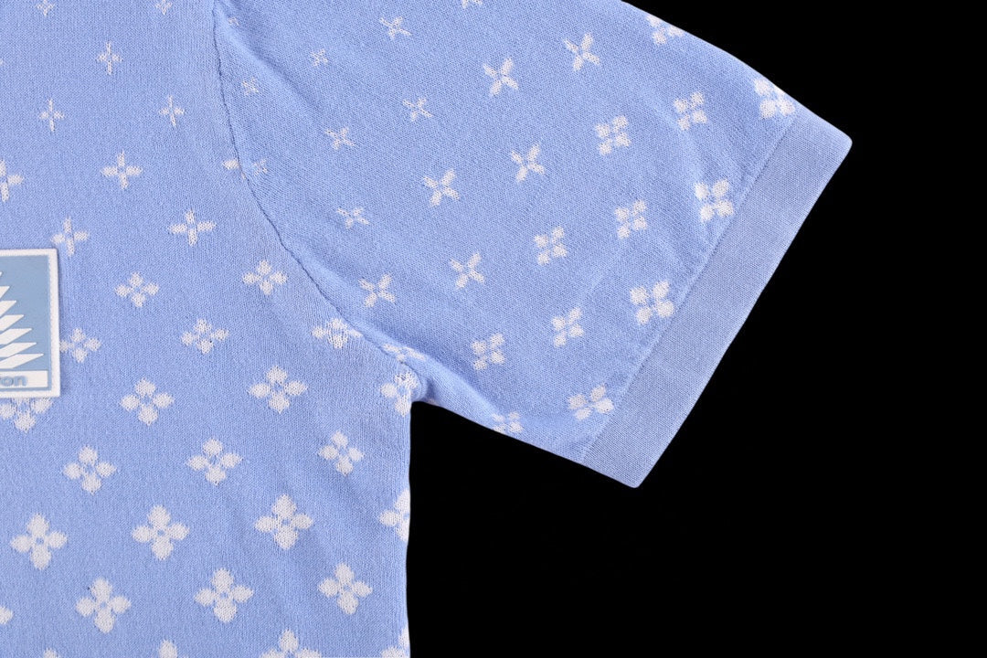 Light blue short-sleeve shirt showing side seam and curved hem with white repeating pattern