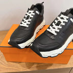 Black unisex sneakers with white laces, thick treaded white sole.