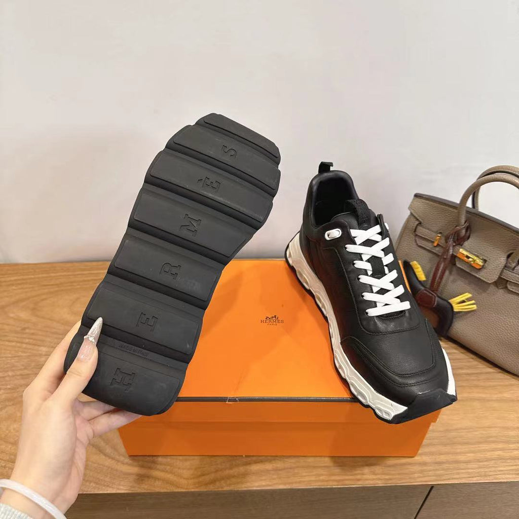 Black sneaker outsole and heel, white laces, chunky white sole.