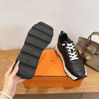 Black sneaker outsole and heel, white laces, chunky white sole.