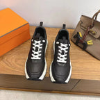 Black unisex leather sneakers, white laces, chunky white rubber sole.