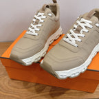Beige lace-up sneakers with white laces and padded collars, close-up pair.