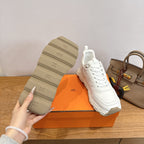 Sneakers outsole view, thick rubber tread and Hermes logo, white lace-up