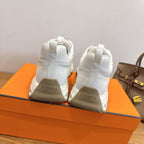 White sneakers with heel branding, lace-up design and cushioned sole, Hermes style