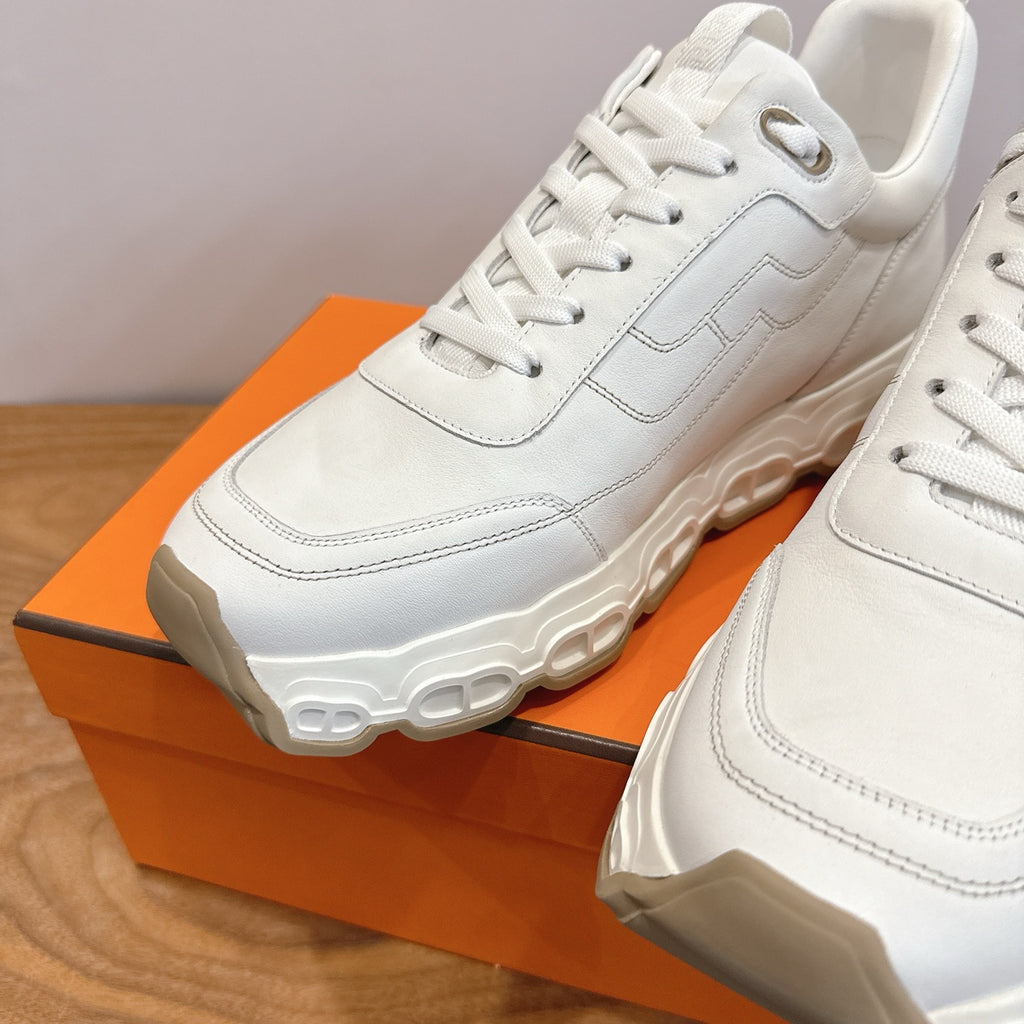 White lace-up sneakers, close-up of laces and cushioned sole, Hermes style