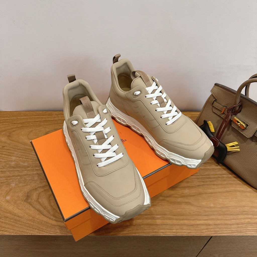 Beige lace-up sneakers with chunky white sole, front angle on shoebox.